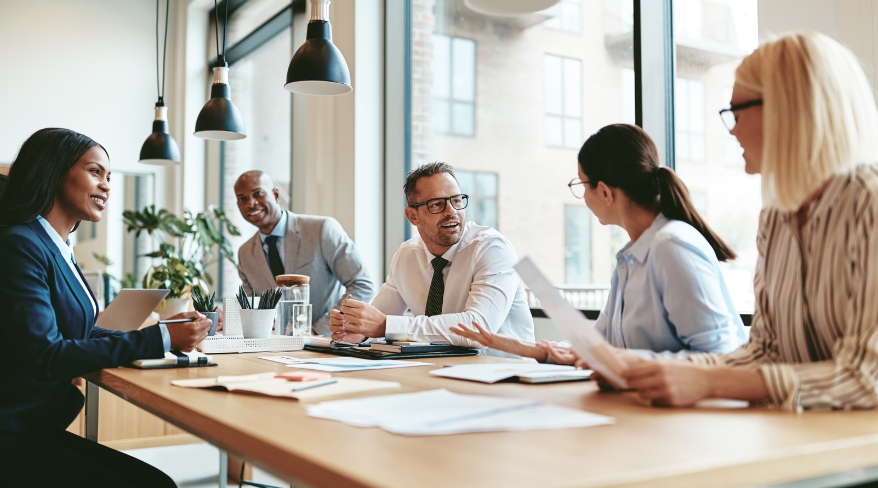 Diverse nonprofit Board members collaborating around a table during a strategy meeting