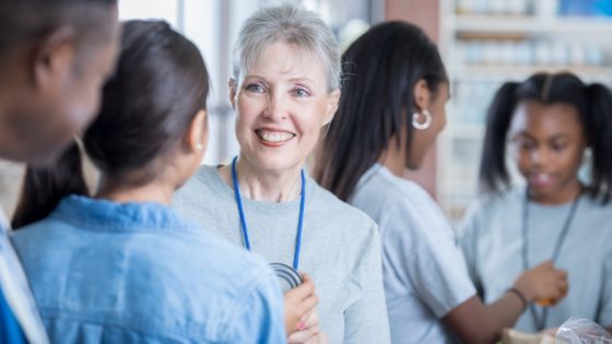 Smiling older woman stands among volunteers, representing gratitude, connection, and nonprofit donor stewardship in action.